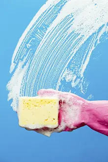 Professional window cleaner with sponge on blue background