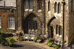 Quaint corner with cobblestone path and flowers near guard housing at The Tower of London