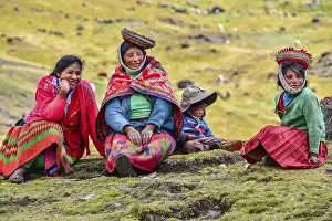 Quechua Indian family in traditional dress sitting in a meadow