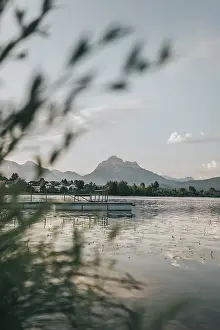 Quiet lake with a jetty, surrounded by mountains and trees