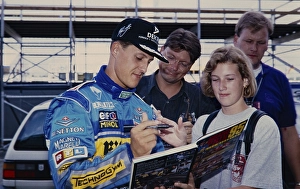 Racing driver Michael Schumacher (Benetton Ford), in blue racing suit gives a fan an autograph, Formula 1 Grand Prix at the Hockenheimring on 30 June 1995, Germany, Europe