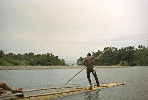 Rafting on the Rio Grande, Port Antonio, Jamaica, Caribbean 1970 Man pushes raft down river through tropical rainforest, Central America