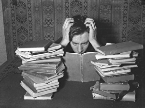 Reading in the 1940s. A young man with his study books in front of him looks as if he is studying hard