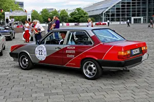 Rear view of a car with red accents at a lively classic car event