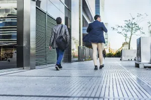 Rear view of two colleagues going to a meeting while they are walking on the street