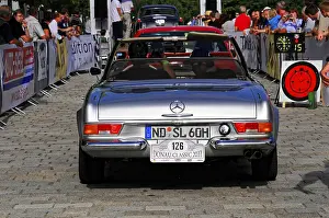 Rear view of a silver Mercedes vintage convertible with crowd in the background