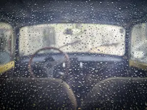 Rear window view into a classic oldtimmer with raindrops