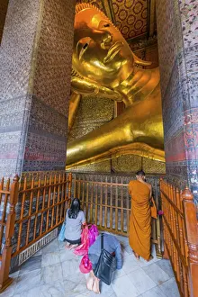 Reclining Buddha with praying monk in Wat Pho temple