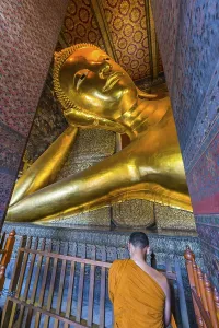 Reclining Buddha with praying monk in Wat Pho temple