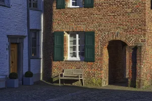Red brick house with green shutters and bench in the shade