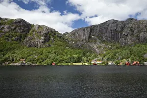 Red cabins by a lake with granite mountains in the background