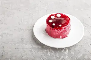Red cake with souffle cream on a gray concrete background