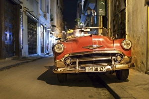 Red classic car, Chevrolet, in narrow alley at night