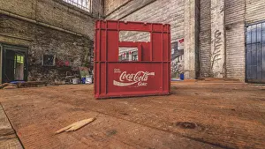 Red Coca-Cola crate in an abandoned factory building in an industrial setting