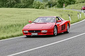 Red Ferrari on a rural road during a race