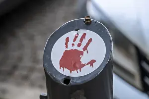Red handprint as a protest symbol on stickers in the cityscape
