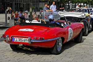 Red Jaguar E-Type convertible at a car event with spectators