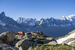 Red tent in front of a mountain panorama