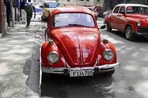 Framed Print : A red VW Beetle vintage car is parked on an urban street surrounded by traffic