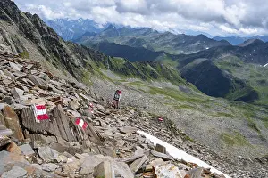 Red and white trail markings, hiker in the high mountains