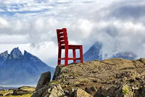 Red wooden chair on a rock, view of Mount Brunnhorn