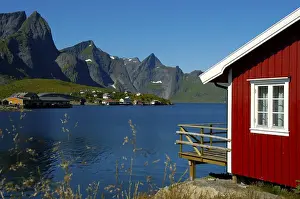 Red wooden house mountains and fjord Hamnoya Moskenesoya Lofoten Norway