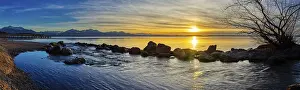 Reflecting sunset scene with mountains and stones on the water at a clear lake