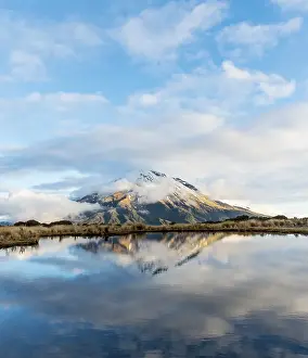 Reflection in Pouakai Tarn, stratovolcano Mount Taranaki or Mount Egmont with cloud