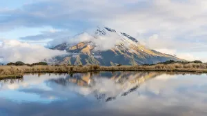 Reflection in Pouakai Tarn, stratovolcano Mount Taranaki or Mount Egmont with cloud