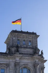 The Reichstag building with the German flag in front of a clear blue sky