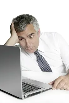 Relaxed senior businessman looking laptop computer white desk background