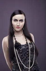 Relaxed woman with long hair and pearl beads - retro style