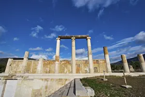 Remains of an ancient temple with majestic columns under a slightly cloudy sky