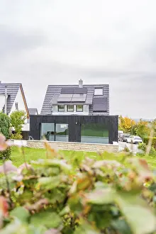 Framed Print : Residential building with black extension and glass front between neighboring houses