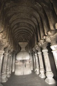 Richly carved stone stupa and pillars in Buddhist caves on mountain at Lenyadri