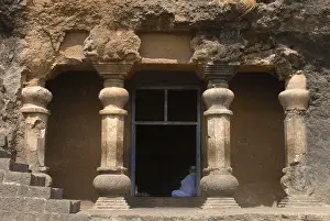 Richly stone carved pillars at the entrance of Buddhist caves on mountain at Lenyadri