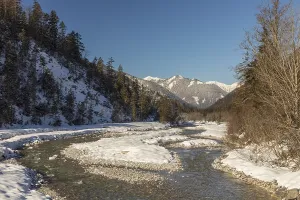 The Riss creek flowing through a snow covered landscape in the Eng valley