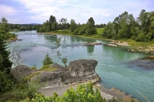 The river bank of the Lech in Lechbruck with a view of a rock formation