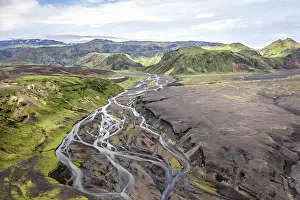 River with fanned out branches through black lava sand