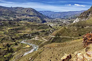 River valley with terraces and mountains under sweeping skies