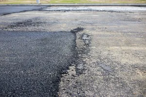 Road with contrasting areas of new asphalt and old surface in a wide view