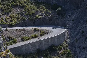 Road cyclist in a curve, mountain road with many curves to Sa Colobra