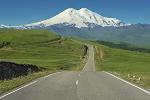 Road leading to mount Elbrus with green meadows at summer
