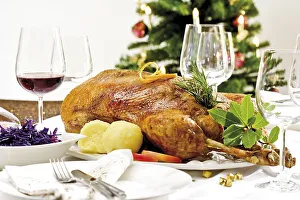 Roast goose, red cabbage, dumplings on a festively decorated table
