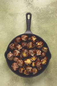 Roasted chestnuts, in an iron pan