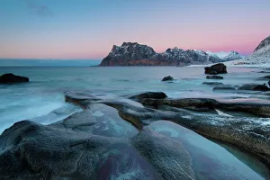 Rock in the sea, back mountains, sunset, Utakleiv, Lofoten, Norway, Europe