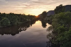 Rocks by the river at sunset, reflection