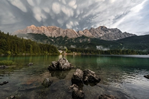 Rocks on the shore, Eibsee lake in front of Zugspitze massif with Zugspitze
