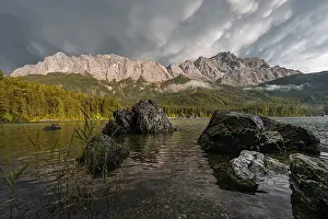Rocks on the shore, Eibsee lake in front of Zugspitze massif with Zugspitze