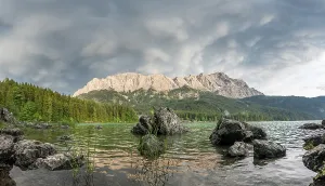 Rocks on the shore, Lake Eibsee lake in front of Zugspitze massif with Zugspitze